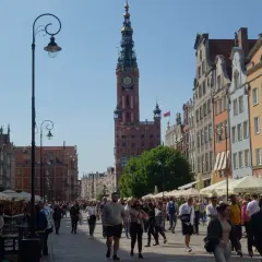 Piękna pogoda w Gdańsku w lipcu. Tłumy spacerują ulicą Długą podziwiając kamienice i Ratusz.