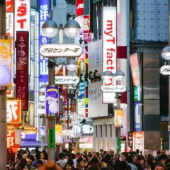 Tłoczna ulica Shibuya w Tokio, jednym z najczęściej odwiedzanych miast świata, pełna neonów i sklepów.