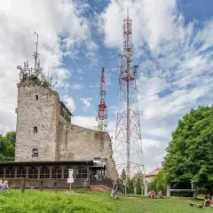 Kamienna wieża i maszty telekomunikacyjne na Chełmcu. Najkrótszy szlak prowadzi do tego miejsca, gdzie odpoczywają turyści.